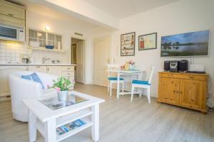 a living room with a white couch and a table at Am Austernstrand in List