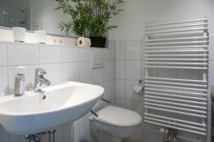 a white bathroom with a sink and a toilet at Iikhoarn in List