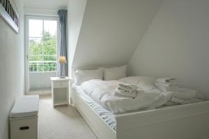 a white bed in a room with a window at Iikhoarn in List