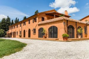 un gran edificio naranja con un camino delante de él en Villa Uliveto, en Staffolo