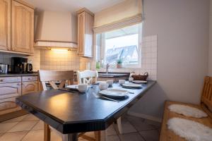 a kitchen with a large black table in a room at Lister Reede Garten in List