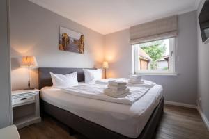 a bedroom with a bed with towels on it at Lister Reede Garten in List