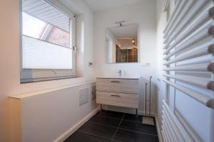 a bathroom with a sink and a mirror at Lister Reede Garten in List +17 photos