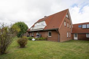 a large brick house with a grass yard at Lister Reede Garten in List