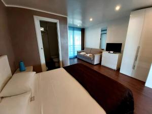 a bedroom with a large bed and a living room at Beach Club Ippocampo in Ippocampo