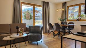 a living room with a couch and tables and chairs at Apartment Streif LXL in Kirchdorf in Tirol
