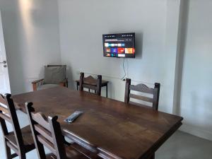 a dining room table with chairs and a television on the wall at Como en casa in Concordia