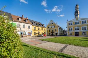 a group of buildings on a street with a tower at Penzion, restaurant Gloria in Chrastava
