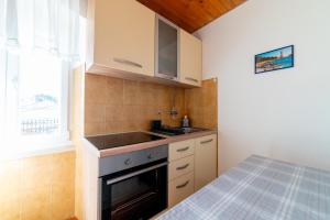 a kitchen with a sink and a stove at Nikola apartment in Božava