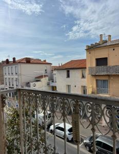 a balcony with cars parked in a parking lot at T4 proche centre et stade de Rugby in Perpignan