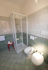 a bathroom with a toilet and a shower and a sink at Hotel Ferrara in Cattolica
