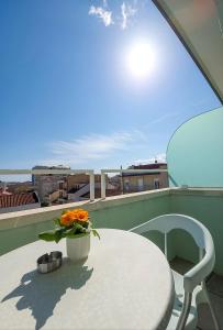 a table with a vase of flowers on a balcony at Hotel Ferrara in Cattolica