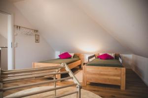 a attic room with two beds and a staircase at Gulfhof Wangermeer 8 Maila in Hohenkirchen