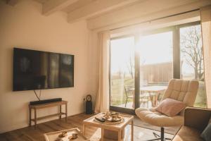 a living room with a couch and a tv at Gulfhof Wangermeer 8 Maila in Hohenkirchen