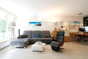 a living room with a couch and a table at Strandresidenz Timmendorfer Strand Seglernest in Timmendorfer Strand