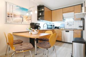 a kitchen with a wooden table and chairs at Strandresidenz Timmendorfer Strand Seglernest in Timmendorfer Strand