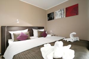 a bedroom with a bed with white sheets and purple pillows at Strandresidenz Timmendorfer Strand Seglernest in Timmendorfer Strand