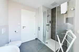 a white bathroom with a shower and a toilet at ADAPT APARTMENT HOTEL Wetzlar in Wetzlar +48 photos