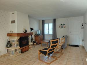 a living room with a fireplace and a table and chairs at Spacieuse maison "Des 3 filles" pour 6 personnes in Ally