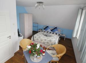 a living room with a table and a bed at Hotel/Pension Bradhering in Ahrenshoop