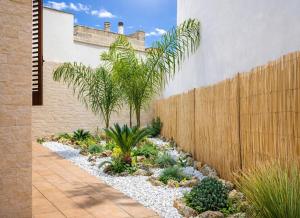 a garden with palm trees and rocks in front of a fence at Quintessenza- Luxury Suites in Leverano +90 photos