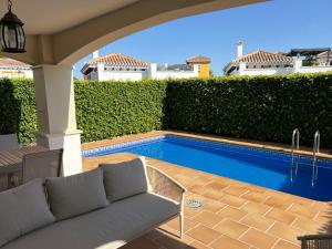 a patio with a couch and a swimming pool at Villa with private pool and BBQ on Mar Menor Golf Resort in Torre-Pacheco