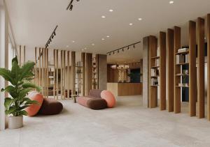 a library with brown and orange chairs and bookshelves at Yugo Terrassa Can Telar in Terrassa