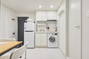 a white kitchen with a washer and dryer in it at Travel Home in Seoul +32 photos