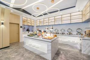 a large kitchen with a counter with food on it at Atour Hotel Maqun Nanjing in Nanjing +43 photos