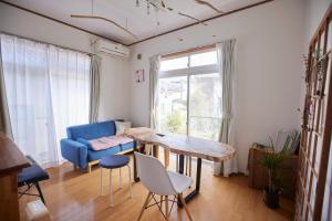 a living room with a table and a blue couch at Tsushima White House in Tsushima