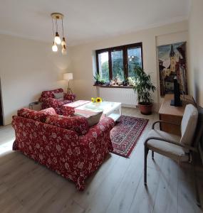 a living room with a red couch and a table at Hidden Gem Villa & Gated Parking in Český Krumlov