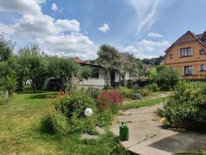 a yard with a house and a garden with flowers at Hidden Gem Villa & Gated Parking in Český Krumlov
