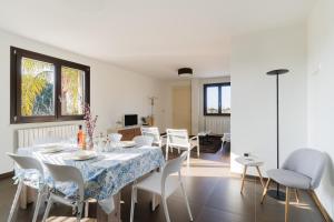 a dining room with a table and white chairs at Intera villa ad uso esclusivo con 2 bagni 4 camere da letto,garage,giardino,area fitness,lavatrice,wifi in Tuglie