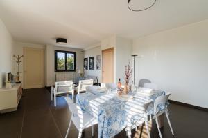 a dining room with a table and white chairs at Intera villa ad uso esclusivo con 2 bagni 4 camere da letto,garage,giardino,area fitness,lavatrice,wifi in Tuglie