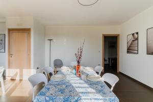 a dining room with a blue and white table and chairs at Intera villa ad uso esclusivo con 2 bagni 4 camere da letto,garage,giardino,area fitness,lavatrice,wifi in Tuglie +36 photos