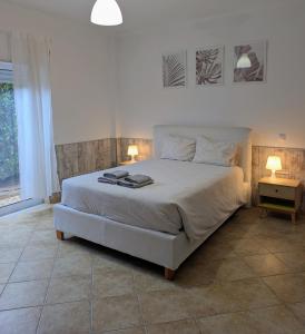 a bedroom with a large bed with two lamps on it at Apartamento Mahalo in Sagres +18 photos