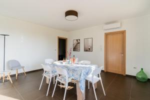 a dining room with a table and white chairs at Intera villa ad uso esclusivo con 2 bagni 4 camere da letto,garage,giardino,area fitness,lavatrice,wifi in Tuglie