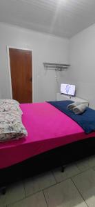 a bedroom with a bed with pink and blue sheets at Pousada familiar 05 in Rio do Sul