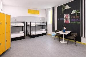 a room with two bunk beds and a table at Bohoostel in Bologna