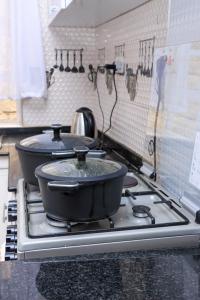 two pans on top of a stove in a kitchen at Zaya Luxe Home in Naivasha +22 photos