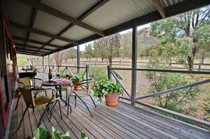 a patio with a table and chairs on a deck at Serenity Grove in Broke