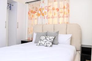 a bedroom with a white bed with two pillows at Zaya Luxe Home in Naivasha