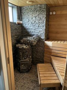 a sauna with a wood stove and a bench at Rooftop Spa Villa Kuressaare in Kuressaare