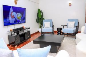 a living room with a tv and two chairs at Zaya Luxe Home in Naivasha