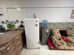 a kitchen with a refrigerator next to a couch at شاليه بقريه روجينا العين السخنه in Ain Sokhna