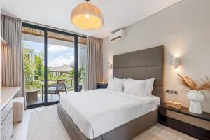 a bedroom with a large bed and a balcony at Balangan Residence in Payangan