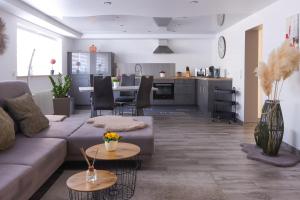 a living room with a couch and a kitchen at Ferienwohnung Nachtweide in Wadgassen