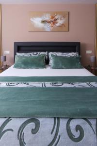a bedroom with a large bed with green sheets and pillows at Ferienwohnung Nachtweide in Wadgassen