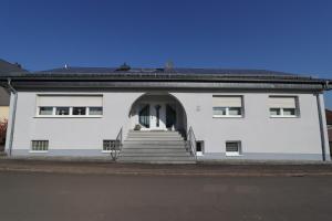 a white building with stairs in front of it at Ferienwohnung Nachtweide in Wadgassen