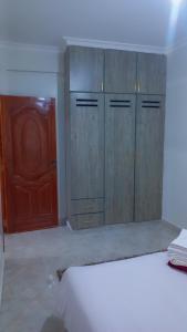 a kitchen with wooden cabinets and a red door at Panorama bnbs meru in Meru